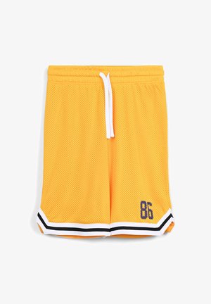Pantaloni da basket in rete gialla con coulisse bianca, orlo a strisce bianche e nere, e numero "86" ricamato in blu navy sul lato sinistro.