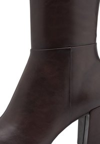 Dark brown leather ankle boot with a smooth texture, featuring a block heel and a minimalistic design without hardware or embellishments.