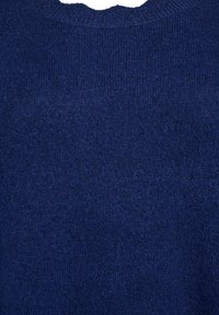 Gros plan sur un tissu en tricot bleu marine avec un col rond côtelé et une surface douce et texturée.