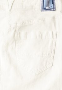 Hvid bomuldsstof med en synlig baglomme med en broderet kant. Mærket viser "CECI" i blåt på en rektangulær baggrund.
