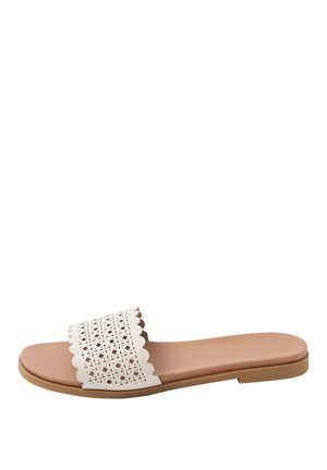 Platte sandalen in lichtbruin met een brede witte geperforeerde band, voorzien van een gekartelde rand en een ontwerp met geometrische uitsnijdingen.