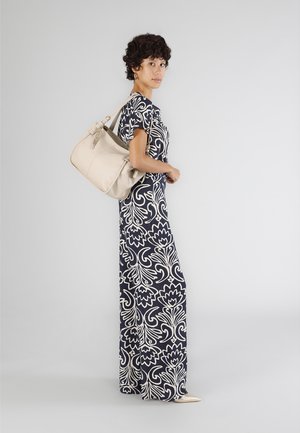 Abito lungo a fiori navy e crema con maniche corte, abbinato a una borsa in pelle beige e a delle scarpe beige con punta.