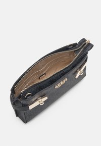 Svart texturerad handväska med guldfärgade detaljer och dragkedjestängning. Inuti finns flera fack och en logotyp accent.