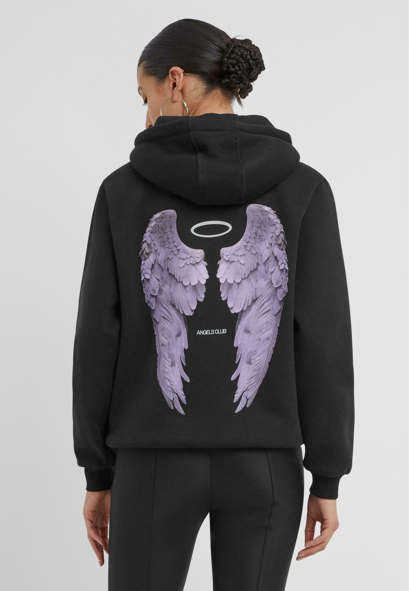 Svart hettegenser med et stort grafisk trykk av lilla englevinger på baksiden, med teksten "ANGELS CLUB" under designet. Myk tekstur.