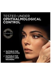 Woman applying mascara with text highlighting product tested under ophthalmological control, suitable for sensitive eyes and contact lens wearers.