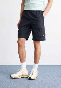 Marine cargo shorts laget av lett stoff, med lommer med glidelås, elastisk midjebånd og en liten logoakcent på siden.