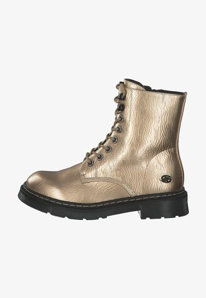 Bota de combate con cordones metálica dorada con suela negra gruesa y ojales, cuero texturizado y diseño hasta el tobillo.