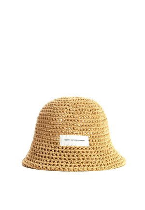 Sombrero tipo bucket tejido en color beige con una etiqueta rectangular blanca que dice “mwwm x mod wave movement” sobre un fondo blanco.