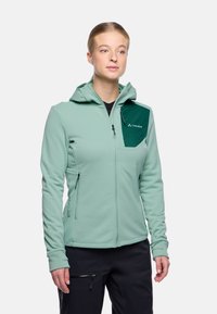 Felpa verde chiaro con zip frontale, cappuccio regolabile e tasca sul petto verde scuro. Presenta un tessuto morbido e dettagli a contrasto.