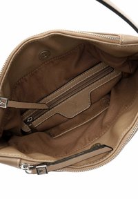 Intérieur d'un sac à main tan avec doublure en cuir lisse, poche zippée et coutures contrastées. Comprend un compartiment principal et des emplacements pour cartes.