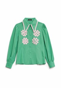 Zelen bluzon dolgih rokavov s koničastim ovratnikom in roza cvetličnim vezenjem na prsih. Narejen iz gladkega, lahkega blaga.