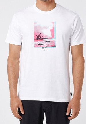 T-shirt blanc avec un graphisme rose et bleu d’un soleil au-dessus de l’eau et le texte "resell projects", porté par une personne debout.