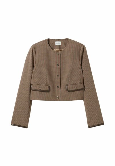 Veste courte en motif pied-de-poule brun et crème, avec un col rond, des manches longues et deux poches avant avec des bordures brunes.
