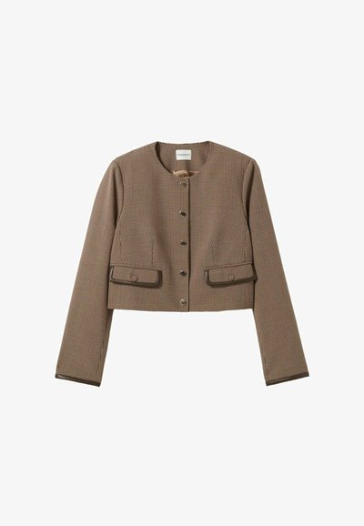 Giacca cropped in un motivo a scacchi marrone e crema, con scollatura rotonda, maniche lunghe e due tasche frontali con rifiniture marroni.