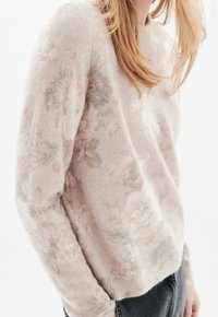 Kukallinen neulepusero pehmeästä, vaaleanpunaisesta materiaalista, jossa on rento istuvuus. Mukana pitkät hihat ja ribbireunus, teksturoidun pinnan kanssa.