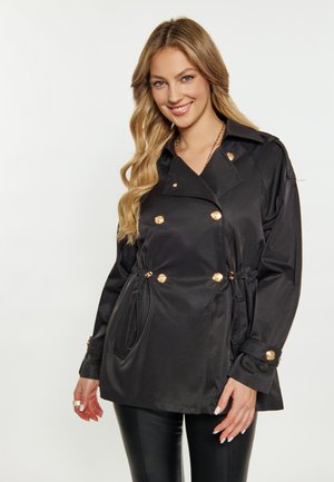Cappotto trench nero con design doppiopetto, bottoni color oro, vita regolabile con cordino e maniche lunghe con polsini abbottonati.