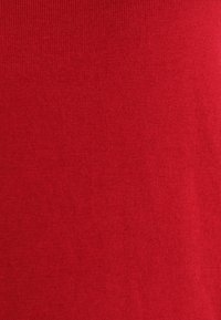 Tissu tricoté rouge avec un tissage fin et régulier ainsi qu'une texture lisse, uniformément coloré en rouge vif.