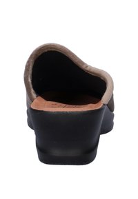 Lichte suède instapper in tan met een gebogen achterkant, zwarte rubberen zool en lichtbruine binnenzool. Glad oppervlak en een eenvoudig ontwerp.