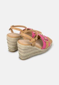 Wedge sandalen met een tan gekleurde faux leren bovenkant, roze gevlochten banden en een gevlochten jute hak die is benadrukt met zilveren details.