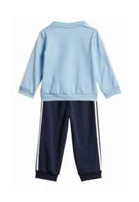 Felpa azzurra chiara con strisce bianche sulle maniche, abbinata a pantaloni blu navy con strisce bianche sui lati. Realizzata in tessuto morbido, vestibilità rilassata.