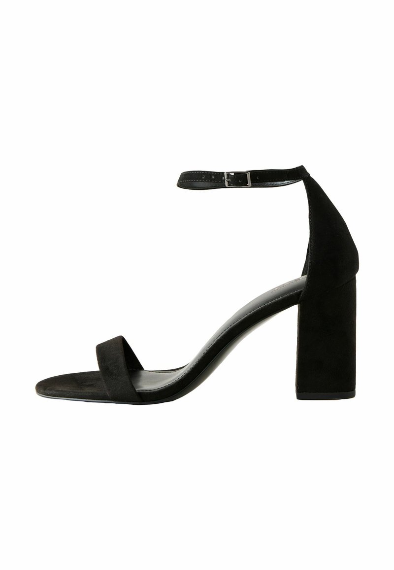 Sandale noire en daim à talon haut avec un talon bloc chunky, une fine sangle avant et une sangle de cheville avec une boucle en métal pour l'ajustement.