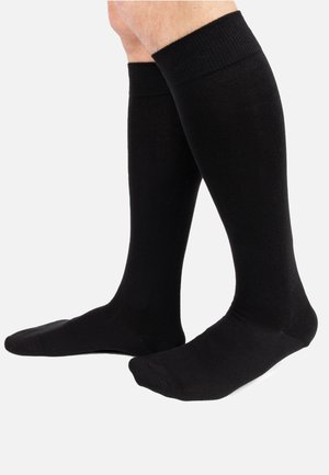 Calze nere fino al ginocchio realizzate in un tessuto liscio e elasticizzato, con orlo a coste e punta rinforzata. Design minimalista, adatto a diverse occasioni.