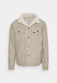 Beige kordjacka med fuskpälskrage, knäppning framtill, två bröstfickor och textil med struktur. Har ett quiltat innerfoder.