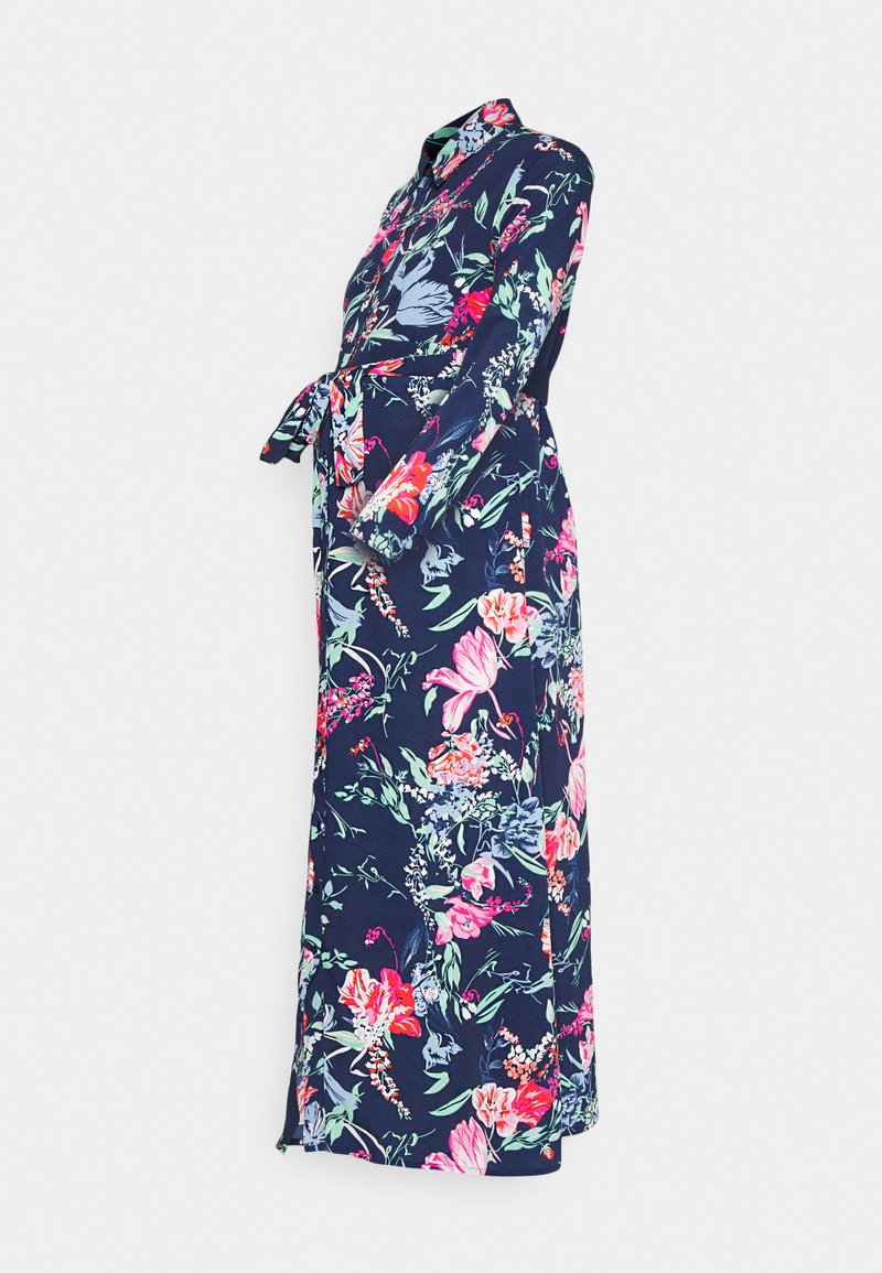 Vestido de manga longa, azul-marinho, com um padrão floral em rosa, verde e azul. Apresenta um decote com gola e um laço na cintura para ajuste.