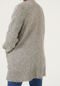 Grauer gestrickter Cardigan mit lockerem Schnitt, geripptem Saum und strukturiertem Stoff. Lange Ärmel und seitliche Taschen sichtbar.
