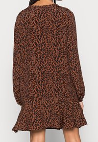 Braun-schwarzes Leopardenmuster-Kleid mit langen Ärmeln, gerüschtem Saum und lockerer Passform, gefertigt aus leichtem Stoff.