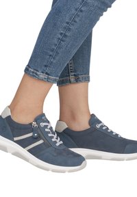 Baskets en suède bleues avec des accents blancs, dotées de lacets et d'une fermeture éclair sur le côté. Texturées avec une semelle rembourrée et un capuchon de talon gris.