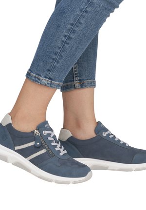 Baskets en suède bleues avec des accents blancs, dotées de lacets et d'une fermeture éclair sur le côté. Texturées avec une semelle rembourrée et un capuchon de talon gris.