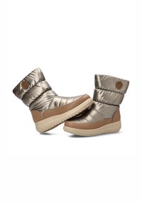 Botas de tobillo con efecto puff metálico en bronce, con parte superior texturizada, suela de goma en tono marrón y parche circular de marca en el lateral. Diseño suave y aislante.