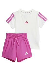 T-shirt bianca in cotone con strisce rosa sulle spalle e logo, abbinata a pantaloni corti rosa con cintura elastica e dettaglio del logo.