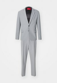 Traje gris claro que consiste en una chaqueta de un solo botón con dos botones y pantalones tapered a juego, confeccionado en una tela suave.