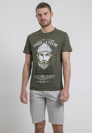 T-shirt en coton vert olive avec un design graphique d'un pêcheur barbu, avec du texte imprimé et des rayures horizontales en bas.
