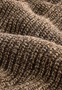 Thick textured fabric in various shades of brown, featuring a ribbed design with multicolored flecks throughout. Soft and layered appearance.