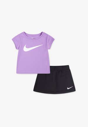 Lila kortärmad skjorta med vit Nike-logga och svart elastisk midjebandkjol med liten vit Nike-logga, tillverkad av lättviktig tyg.