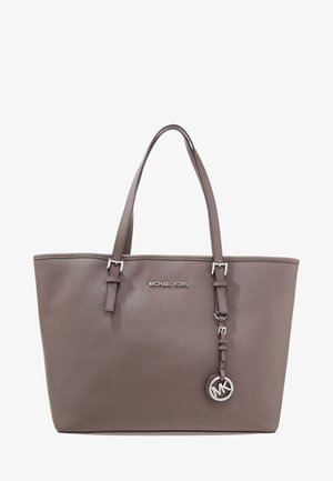 Brązowa torba typu tote z skóry firmy Michael Kors, wyposażona w dwa uchwyty i srebrny wisiorek z logo MK zawieszony na jednym z pasków.