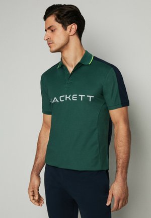 Polo verde con acentos en azul marino, con un cuello tipo collar y el logo 'JACKETT' en gris. Fabricado en tejido texturizado, con mangas cortas.