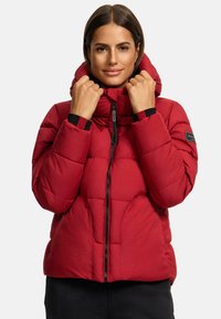 Red puffer jacket featuring a hood, quilted texture, black zipper, and contrasting cuffs. Sleek, insulated design suitable for cold weather.