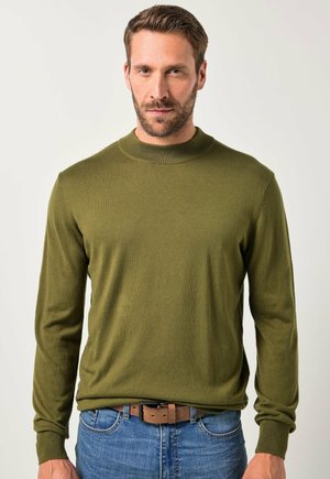 Olivegrüner Pullover aus weichem Strickstoff mit Rundhalsausschnitt und langen Ärmeln, kombiniert mit blauen Jeans und einem braunen Gürtel.