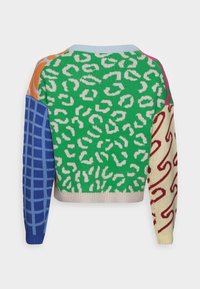 Maglione lavorato a maglia con un corpo verde e macchie leopardate bianche, maniche con motivo a griglia blu, dettagli arancioni e maniche crema con motivo a spirale rosso.