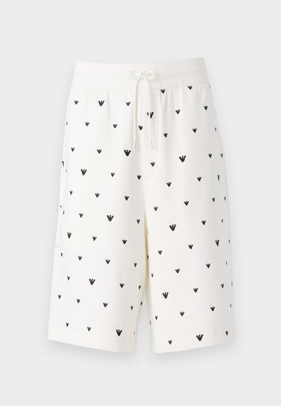 Vita shorts i mjukt tyg med ett svart mönster av små, inverterade trikantformer. Försedda med elastisk midja med dragsko.