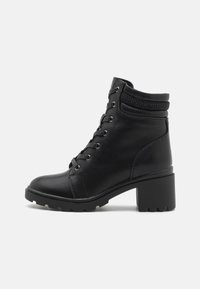 Black ankle boots with a textured upper, featuring a lace-up design, round toe, and a chunky heel. Rugged sole for traction.