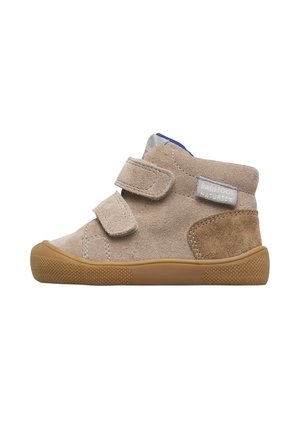 Chaussure beige en daim pour tout-petit avec deux bandes Velcro, semelle en caoutchouc marron et renfort au talon, vue de profil sur fond blanc.