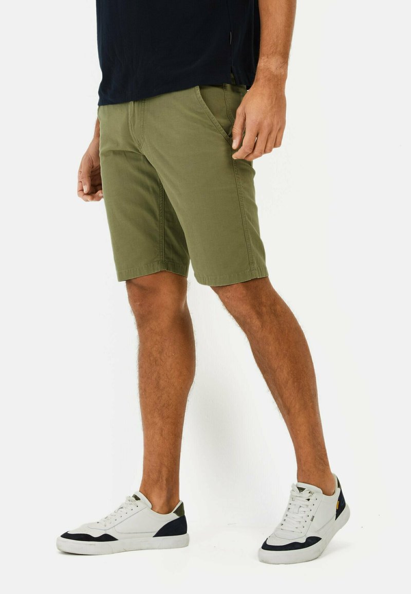 Olijfgroene korte broek van een katoenmix, met zijzakken, een platte voorkant en een relaxte pasvorm. Draag met witte sneakers.