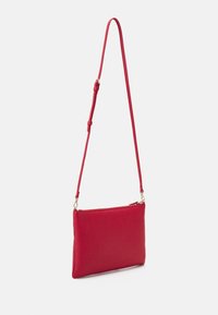 Rød skuldertaske i læder med en glat overflade, slank rektangulær form, justerbar rem og guldfarvet hardware til lynlåsen.