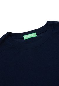 Granatowy sweter z okrągłym dekoltem, wykonany z miękkiej tkaniny, z zieloną metką z napisem "UNITED COLORS OF BENETTON."