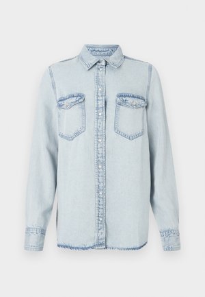 Šviesiai mėlynas džinsinis marškinis su smailiu apykakle, mygtukų uždarymu ir dviem krūtinės kišenėmis. Yra siuvinėjimo detalės ir šiek tiek suplėšytas apvadas.